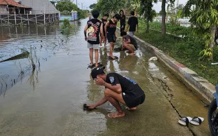 Cegah Pengendara Tergelincir, Momen Lebaran Pemuda Putatkumpul Lamongan Bersihkan Jalan Berlumut Akibat Banjir