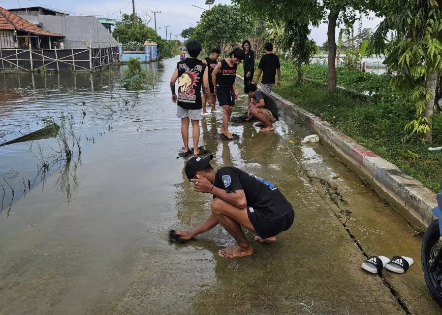 Cegah Pengendara Tergelincir, Momen Lebaran Pemuda Putatkumpul Lamongan Bersihkan Jalan Berlumut Akibat Banjir
